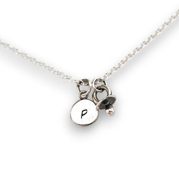 Initial silver disc pendant with baby dummy charm