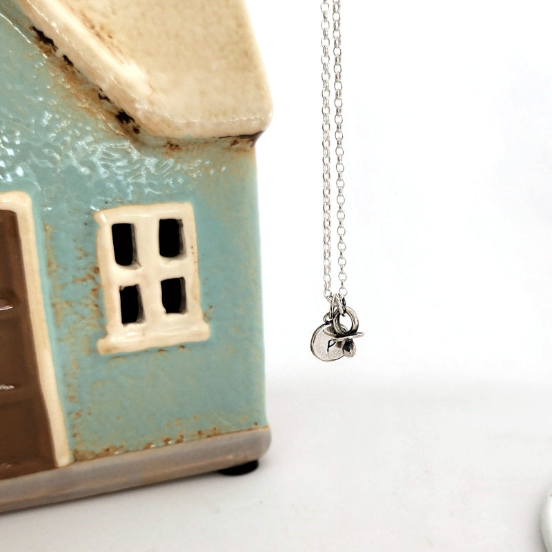 Initial silver disc pendant with baby dummy charm