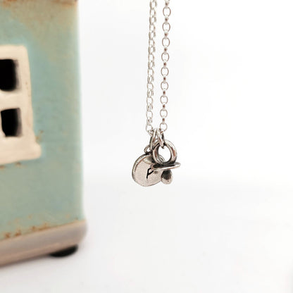 Initial silver disc pendant with baby dummy charm
